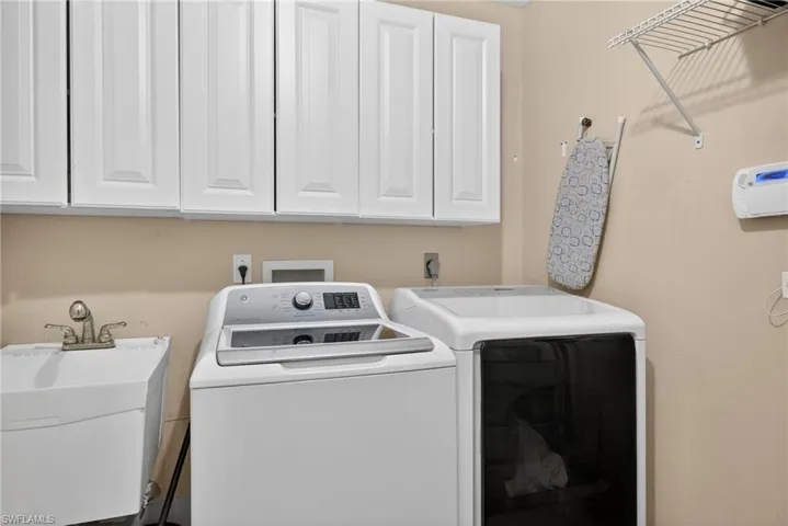 Laundry room with washing machine and clothes dryer and cabinet space