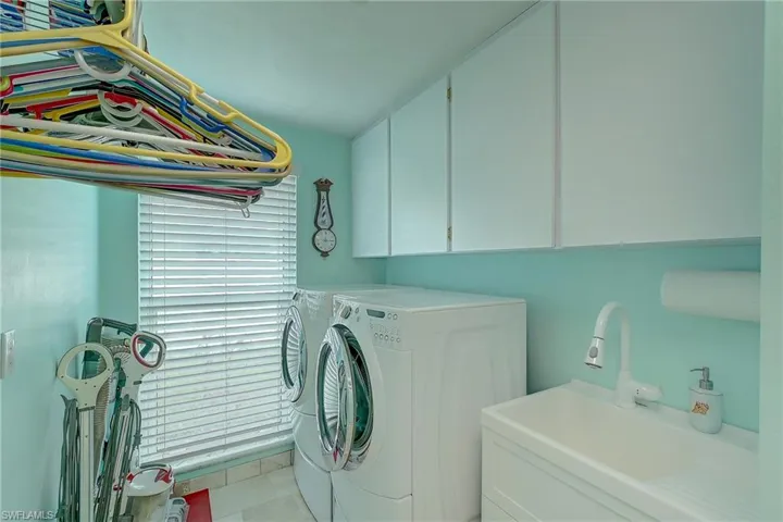 Laundry room with washing machine and clothes dryer and cabinet space