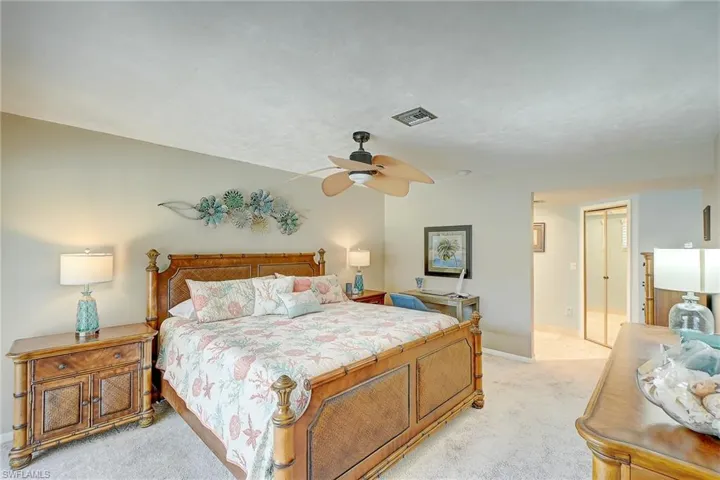Bedroom featuring a closet, light carpet, and a ceiling fan