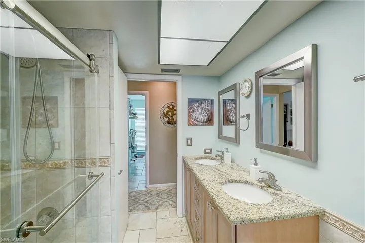 Full bath featuring a shower stall and double vanity