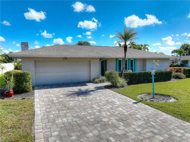 Single story home with a front lawn, decorative driveway, stucco siding, and an attached garage