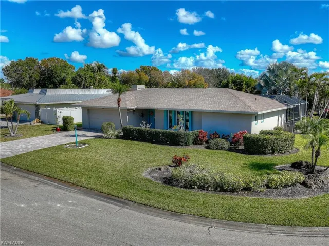 Ranch-style home with a garage, driveway, stucco siding, roof with shingles, and a front yard