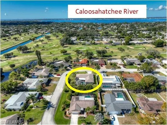 Aerial perspective of suburban area with a local golf course and a nearby body of water