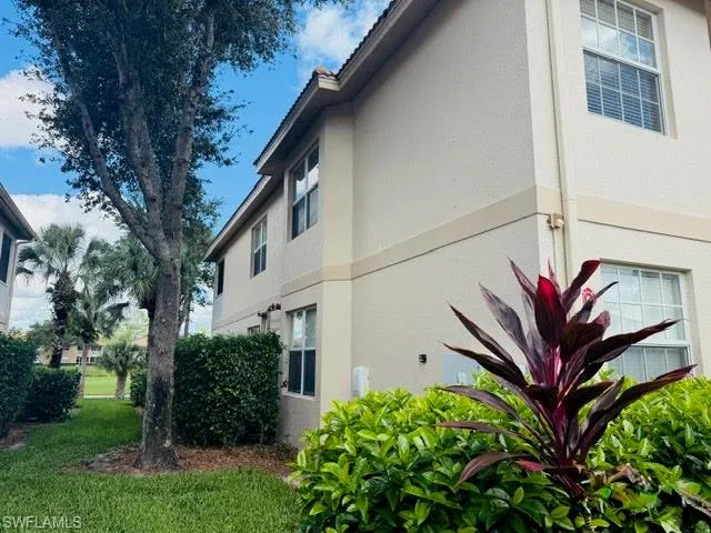 View of side of property with stucco siding and a yard