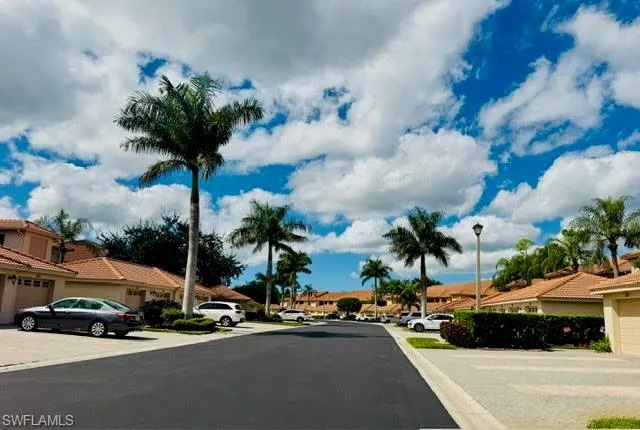 View of asphalt road with a residential view and street lights