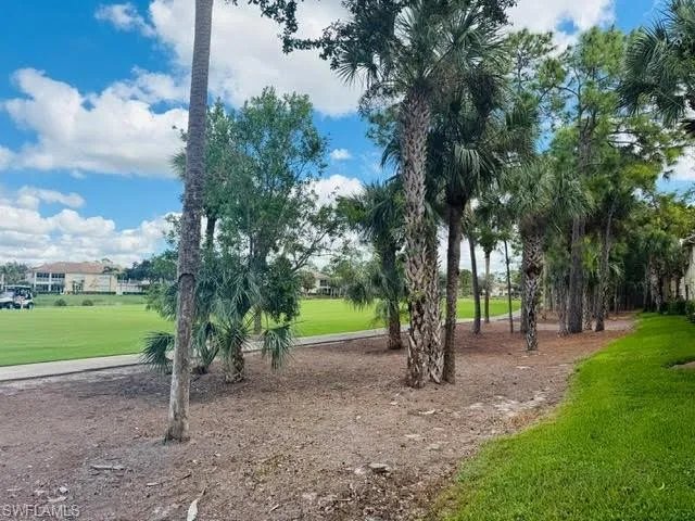 View of property's community with a yard and view of golf course