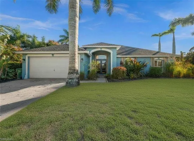 View of front of home with stucco siding, concrete driveway, an attached garage, and a front lawn