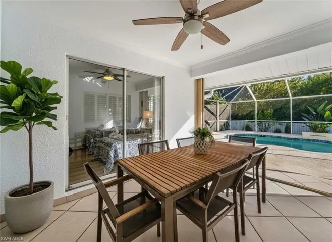View of patio featuring outdoor dining space, a lanai, an outdoor pool, a sunroom, and ceiling fan