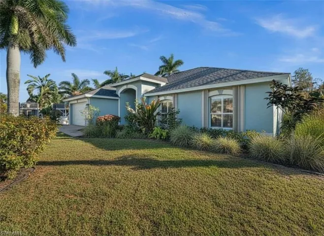 Ranch-style house with stucco siding, an attached garage, a front lawn, and a shingled roof