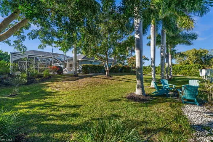 View of grassy yard with glass enclosure and a sunroom