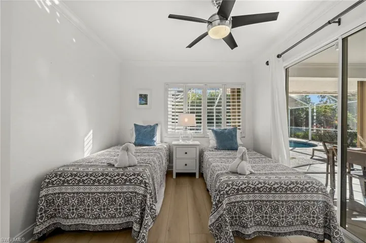 Bedroom with access to exterior, ornamental molding, hardwood / wood-style flooring, ceiling fan, and a sunroom