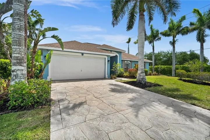 Single story home featuring concrete driveway, a front lawn, a garage, roof with shingles, and stucco siding