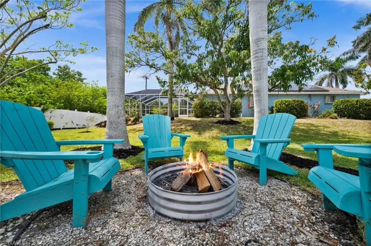 View of yard with a lanai and an outdoor fire pit