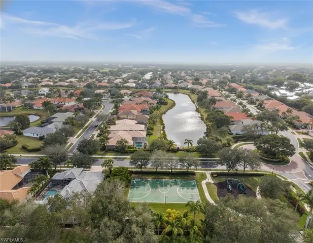 Aerial view of property and surrounding area with a nearby body of water and nearby suburban area