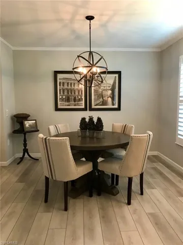 Dining room featuring a chandelier, crown molding, and light wood finished floors
