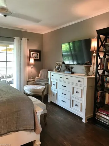 Bedroom featuring crown molding and dark wood-style floors