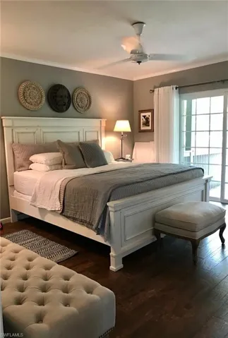 Bedroom with crown molding, wood finished floors, and ceiling fan
