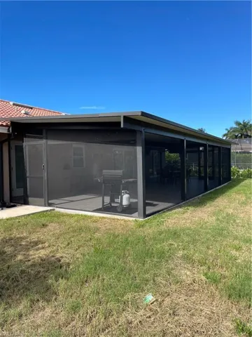 Back of property featuring a sunroom and a lawn