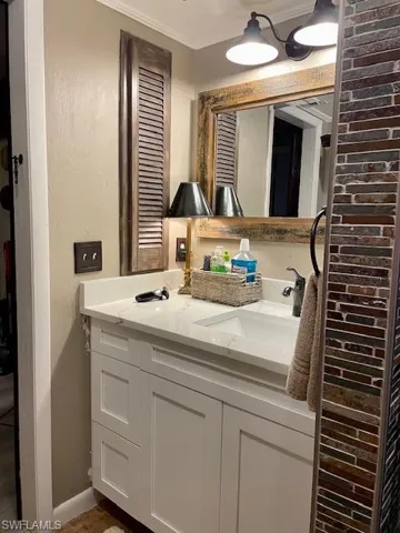 Bathroom with ornamental molding and double vanity