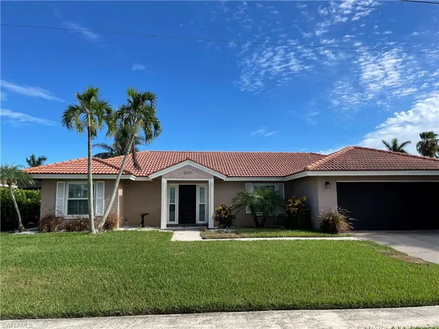 View of front of property featuring stucco siding, a garage, a front yard, and a tile roof