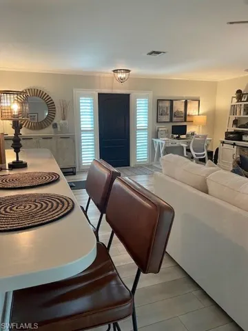 Living area featuring ornamental molding, light wood-type flooring, and a desk