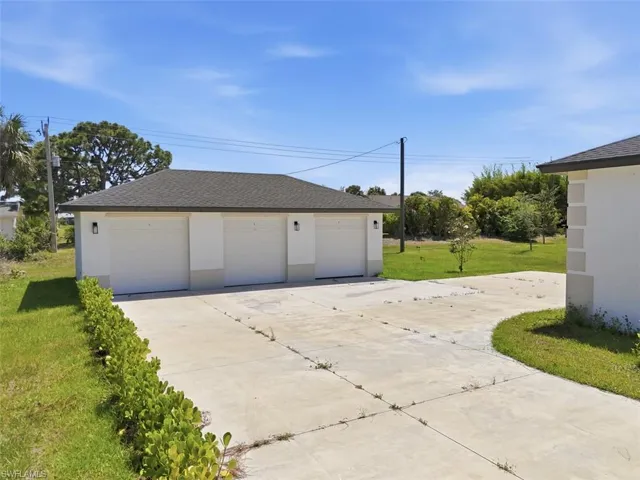 Three-car garage with white paneled doors and modern exterior lighting - 1 per unit