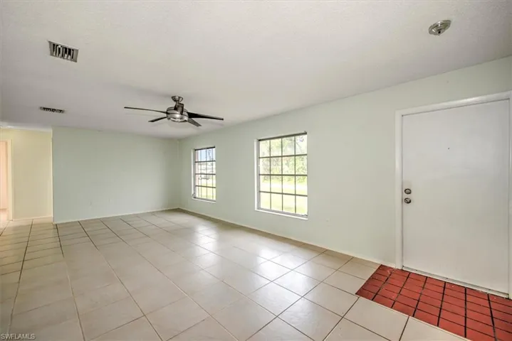 Unfurnished room featuring a textured ceiling, ceiling fan, and light tile patterned floors