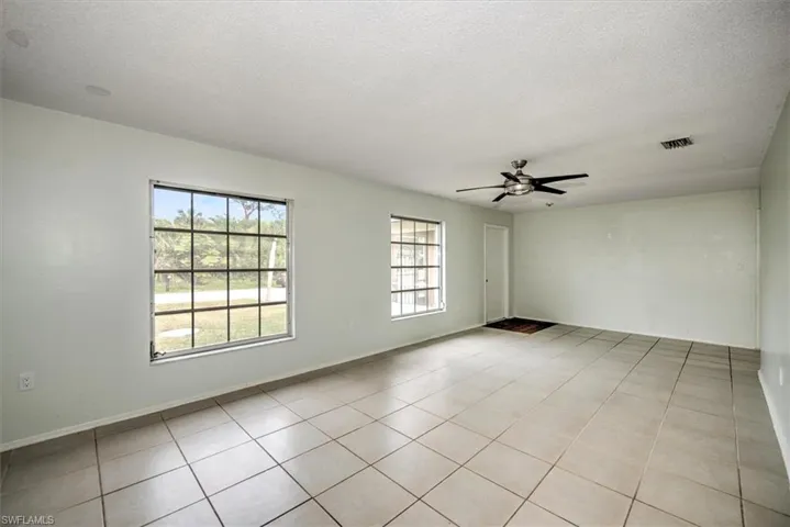 Spare room featuring ceiling fan, a textured ceiling, and light tile patterned flooring