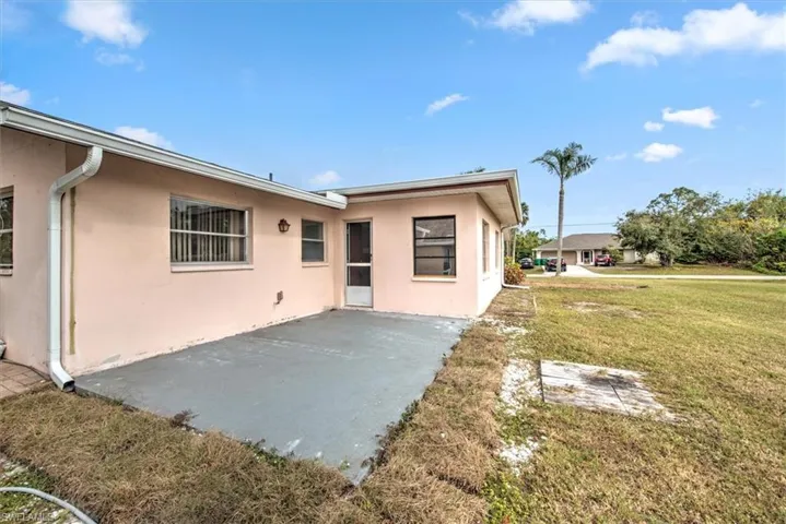 Rear view of house featuring a lawn and a patio