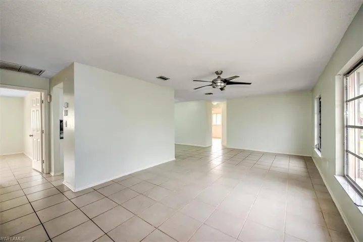 Tiled spare room with ceiling fan and a textured ceiling