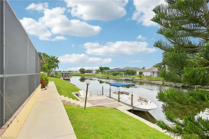 Surrounding community featuring a lawn, a water view, a dock, and a residential view