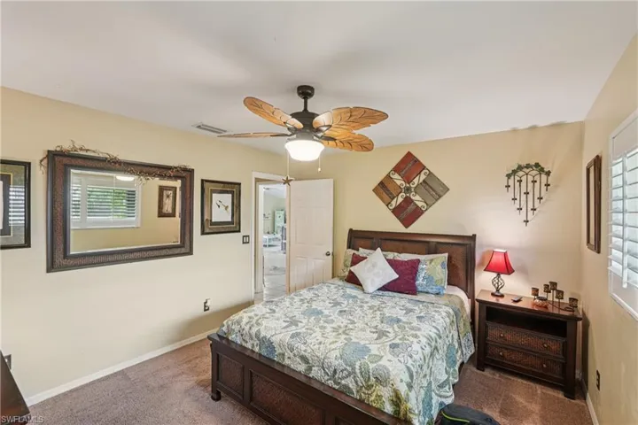 Carpeted bedroom featuring ceiling fan and baseboards