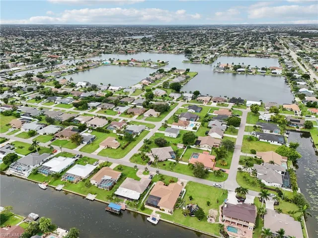 Aerial view of property's location with a nearby body of water and nearby suburban area