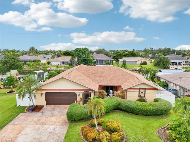 Ranch-style home featuring a residential view, driveway, a garage, stucco siding, and roof with shingles