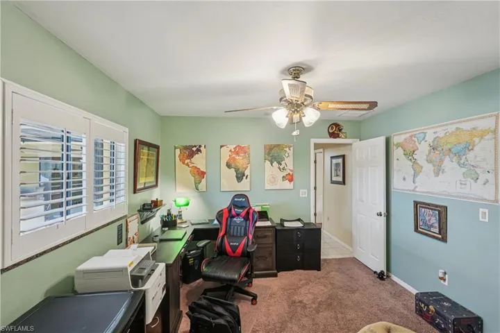 Home office featuring light carpet and ceiling fan