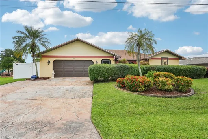 Ranch-style home featuring stucco siding, driveway, a gate, and an attached garage