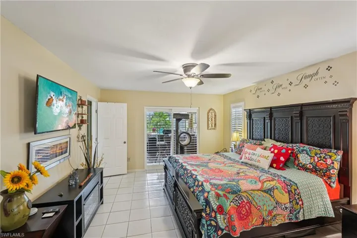 Bedroom featuring light tile patterned floors, access to exterior, and ceiling fan