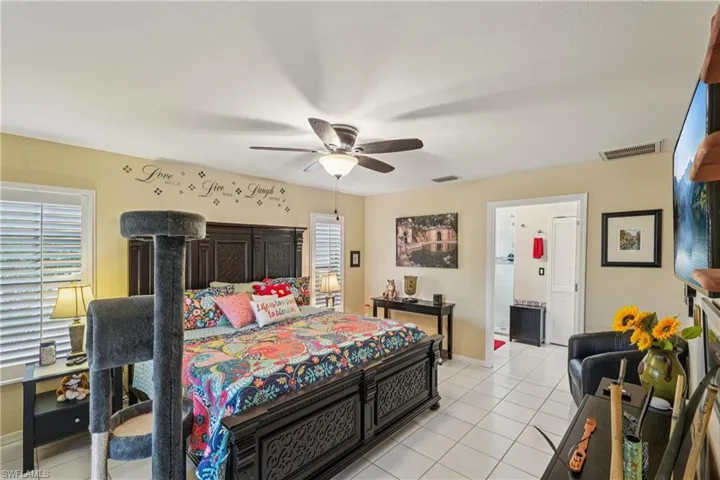 Bedroom with light tile patterned floors and ceiling fan