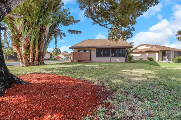 Back of property featuring a sunroom and a yard