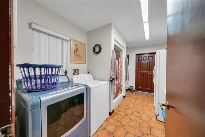 Laundry area featuring washer and clothes dryer and light tile patterned floors