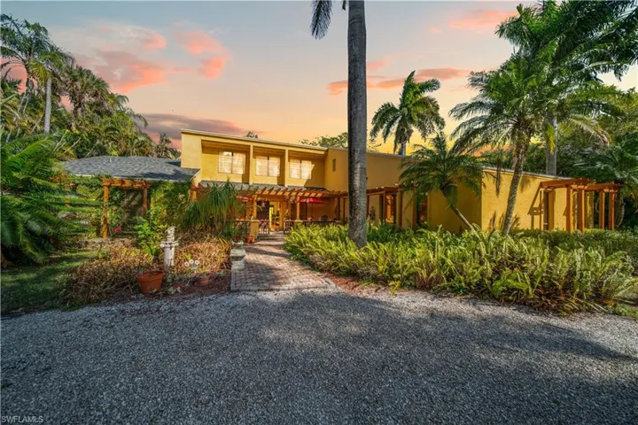 View of front of house featuring stucco siding and a pergola