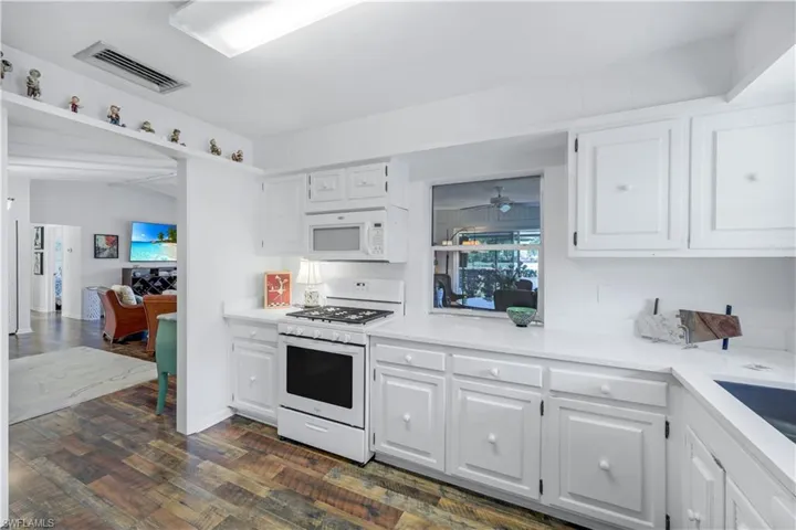 Kitchen with pass through window to lovely dining area.