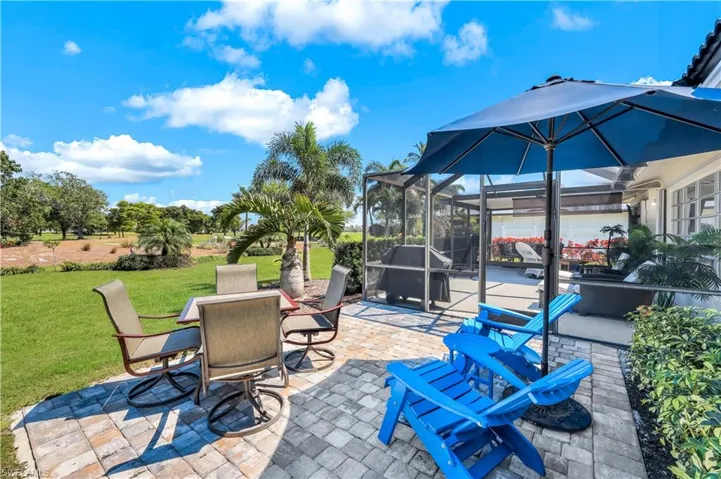 View of patio with outdoor dining area and glass enclosure