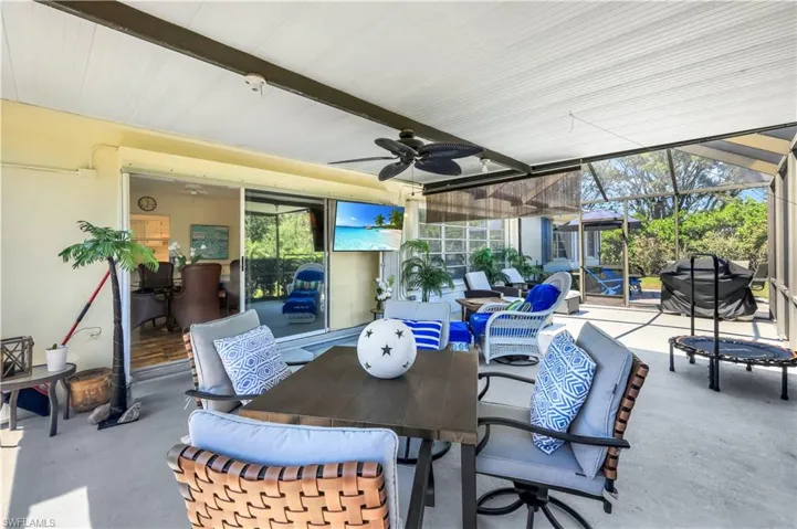 View of patio / terrace featuring outdoor dining space, ceiling fan, and glass enclosure