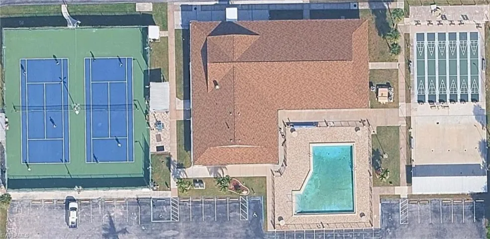Aerial view of main amenity center including a clubhouse, pool, tennis and shuffleboard courts.