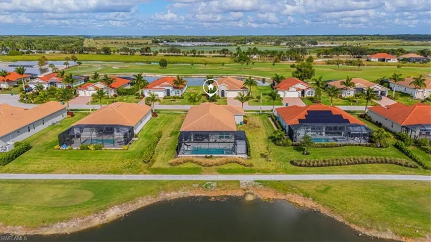 Aerial perspective of suburban area with a nearby body of water and a golf course