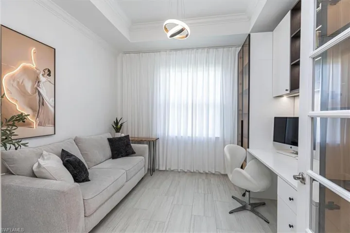 Office area with a raised ceiling and crown molding