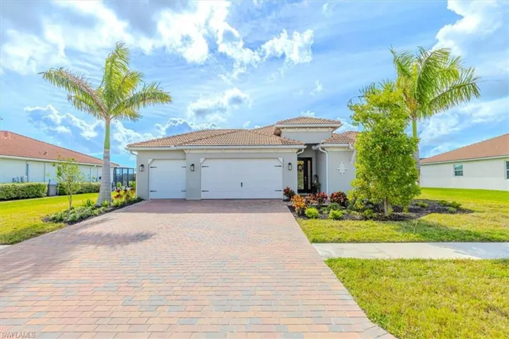 Mediterranean / spanish-style home featuring a front yard, an attached garage, decorative driveway, and stucco siding
