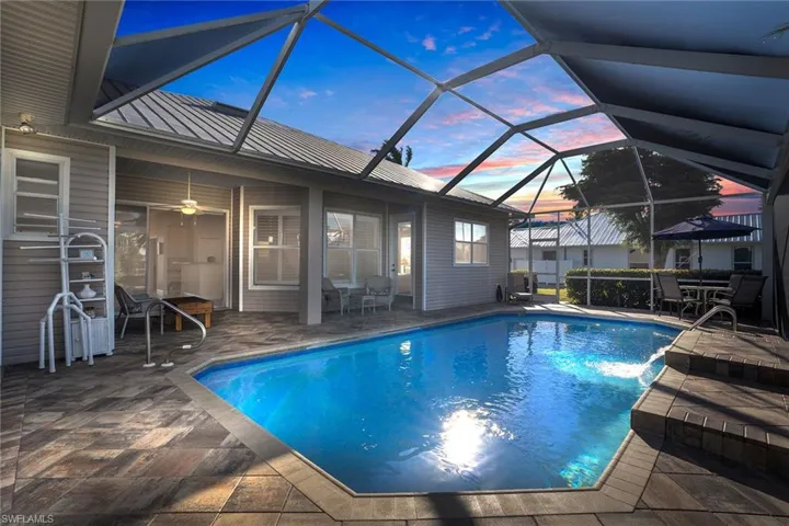 Custom heated pool with waterfall and unobstructed screen view of yard