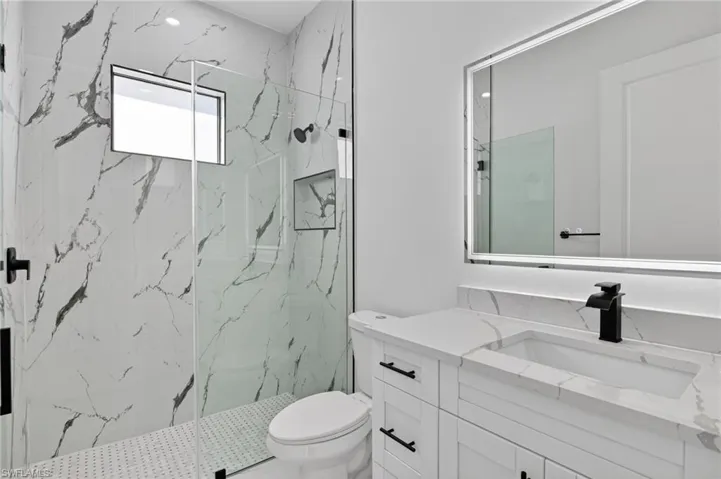 Full bathroom featuring vanity and a marble finish shower